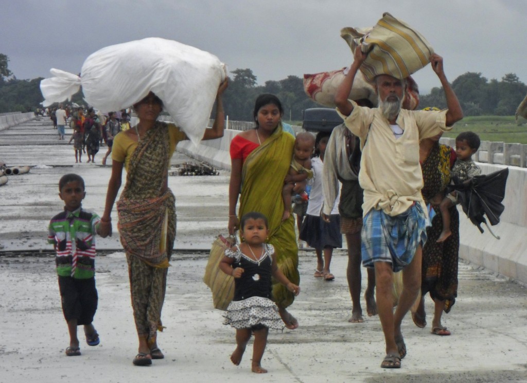 Villagers with their belongings move to relief camps as they leave their locality after violence at Chirang district